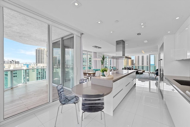 kitchen with white cabinets, light tile patterned floors, black electric cooktop, and island exhaust hood