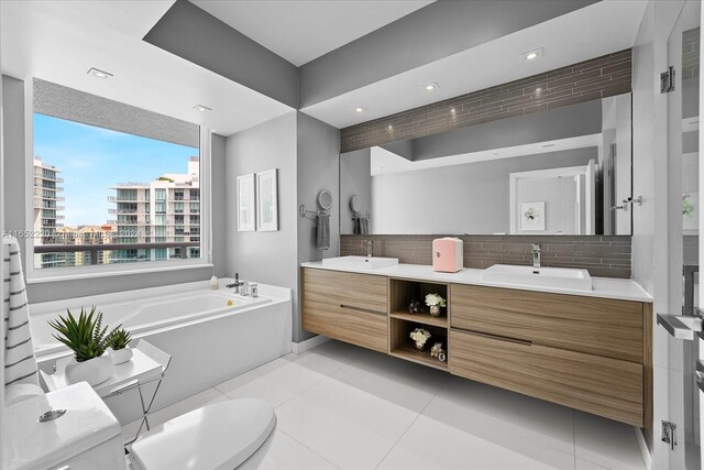 16500 Collins Ave Unit 2451, Sunny Isles Beach, FL 33160 - bathroom featuring backsplash, a bath, toilet, double vanity, and tile patterned floors