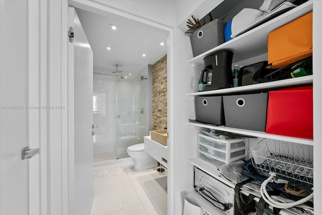 bathroom featuring walk in shower, toilet, vanity, and tile patterned flooring