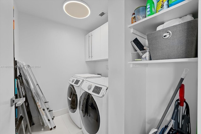 washroom with cabinets, washer and clothes dryer, and light tile patterned flooring