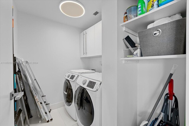 16500 Collins Ave Unit 2451, Sunny Isles Beach, FL 33160 - laundry area featuring washer and clothes dryer, cabinet space, tile patterned flooring, and baseboards
