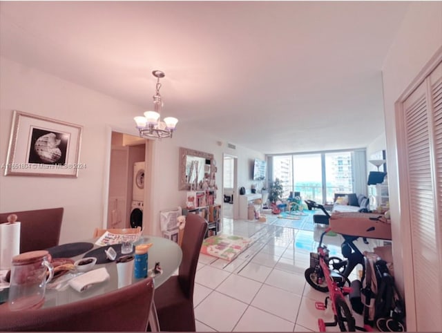 5700 Collins Ave Unit 8B, Miami Beach, FL 33140 - dining space with stacked washing machine and dryer, tile patterned flooring, a chandelier, and floor to ceiling windows
