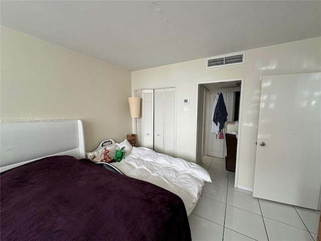 bedroom with a closet and light tile patterned flooring