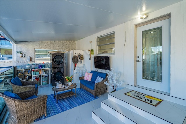exterior space featuring stacked washer and clothes dryer and an outdoor hangout area