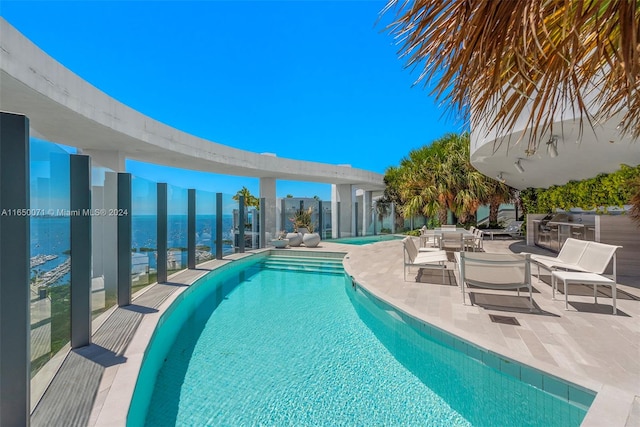 view of swimming pool featuring an outdoor hangout area, a water view, and a patio area