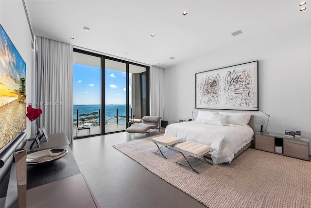 bedroom featuring expansive windows, access to exterior, a water view, and concrete flooring