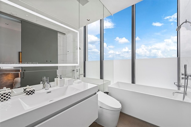 bathroom with vanity, a washtub, and toilet