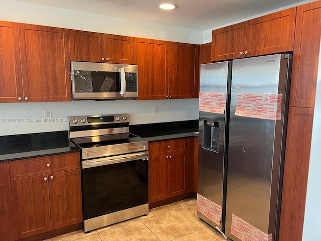 kitchen with appliances with stainless steel finishes and light tile patterned flooring