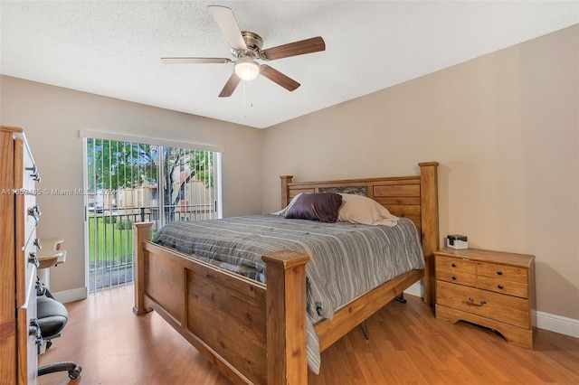 bedroom featuring a textured ceiling, light hardwood / wood-style flooring, access to exterior, and ceiling fan