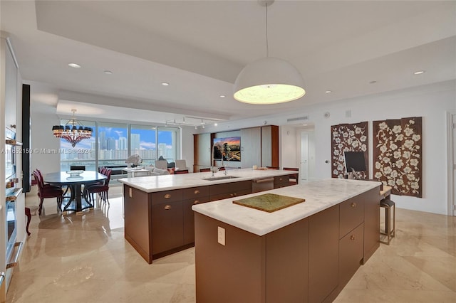 kitchen with a large island, dark brown cabinets, decorative light fixtures, and sink