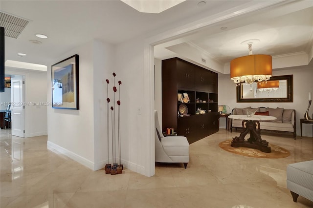 living room with ornamental molding and a chandelier