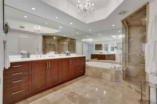 bathroom with an inviting chandelier, independent shower and bath, and vanity