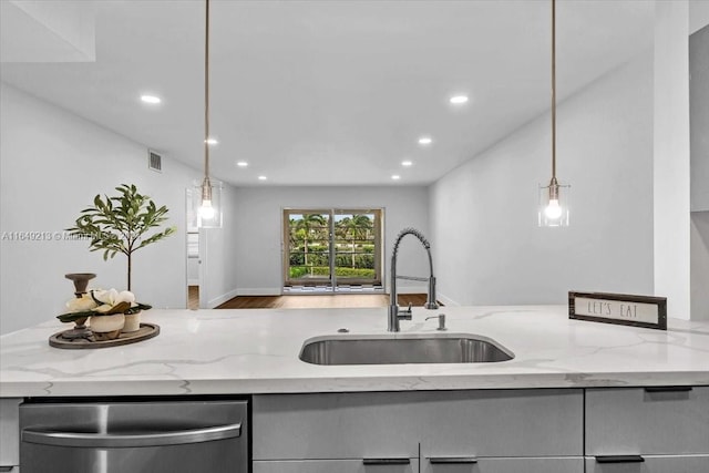 kitchen with dishwasher, sink, light stone countertops, and hanging light fixtures