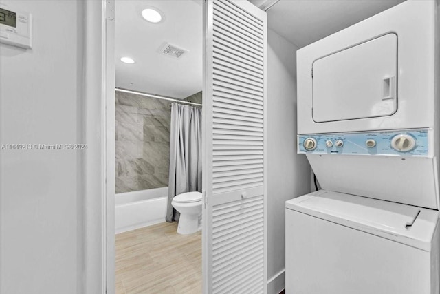 clothes washing area with stacked washer and dryer and light hardwood / wood-style floors