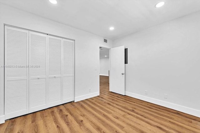 unfurnished bedroom featuring light hardwood / wood-style floors and a closet