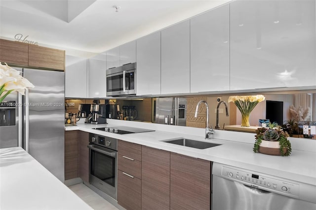 kitchen featuring white cabinets, appliances with stainless steel finishes, tasteful backsplash, and sink