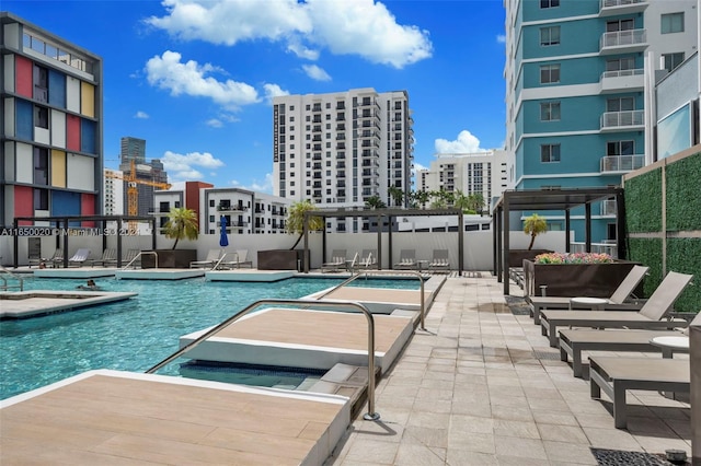 view of swimming pool with a hot tub