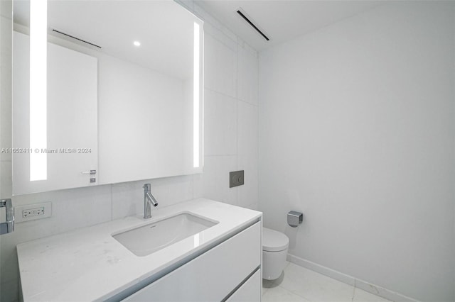 bathroom featuring vanity, toilet, and tile patterned flooring