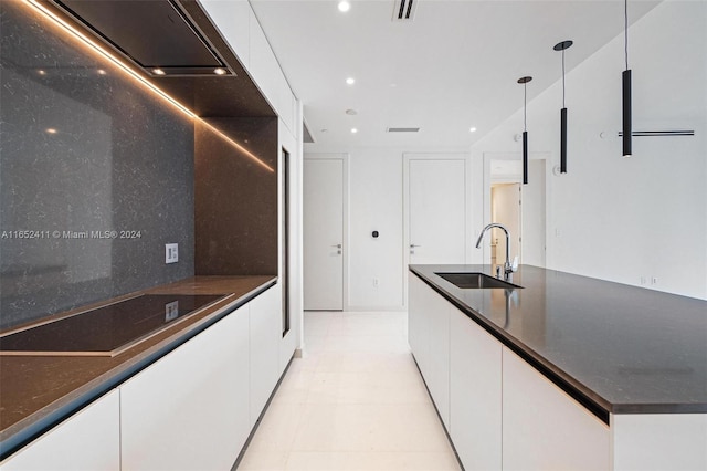 kitchen with pendant lighting, sink, and white cabinetry