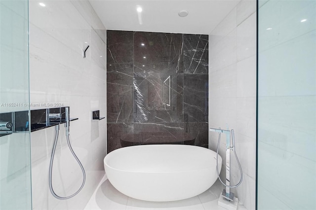 bathroom featuring tile walls and independent shower and bath