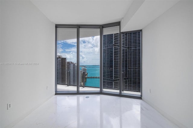 unfurnished room with a wall of windows