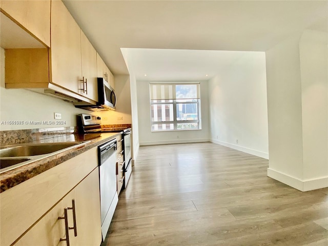 kitchen featuring light brown cabinetry, stainless steel appliances, sink, and light hardwood / wood-style floors