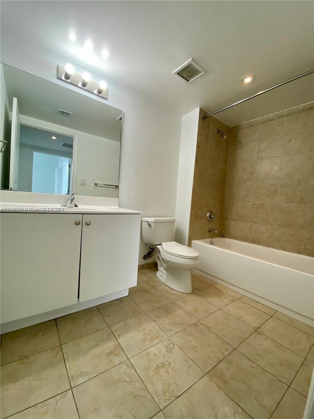 full bathroom with tiled shower / bath, vanity, toilet, and tile patterned flooring