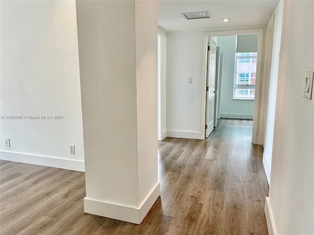 hallway with light hardwood / wood-style floors