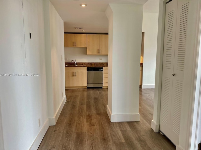 kitchen with dishwasher, hardwood / wood-style flooring, light brown cabinetry, and sink