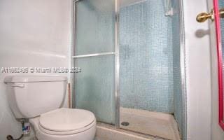 bathroom with an enclosed shower and toilet