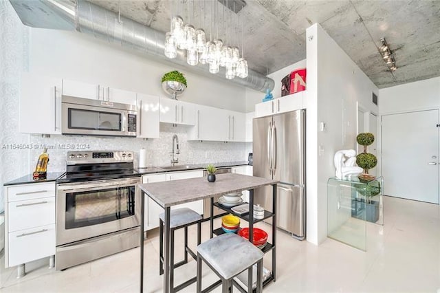 kitchen featuring white cabinets, appliances with stainless steel finishes, tasteful backsplash, and sink