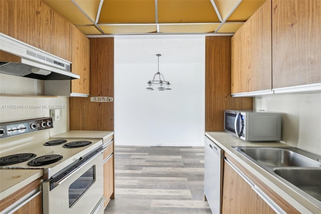 kitchen featuring light hardwood / wood-style floors, sink, hanging light fixtures, white appliances, and extractor fan