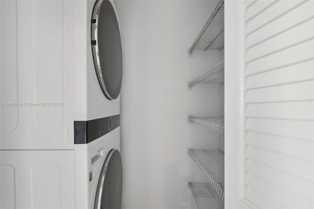 clothes washing area with stacked washing maching and dryer