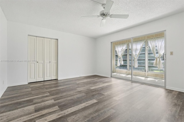 empty room featuring a textured ceiling, dark hardwood / wood-style floors, and ceiling fan