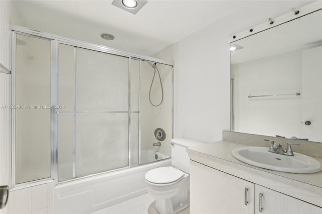 full bathroom featuring shower / bath combination with glass door, vanity, toilet, and tile patterned floors