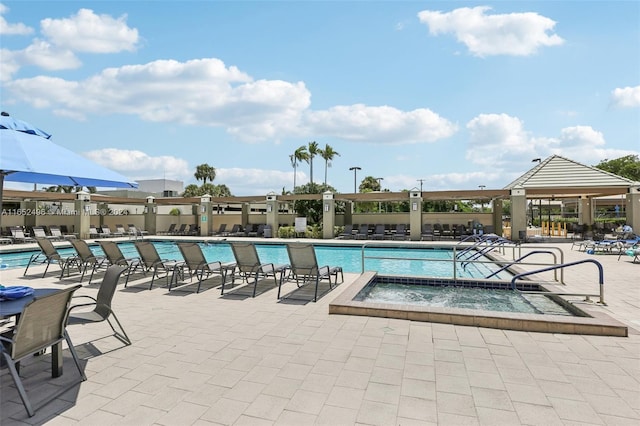 view of swimming pool featuring a hot tub and a patio area