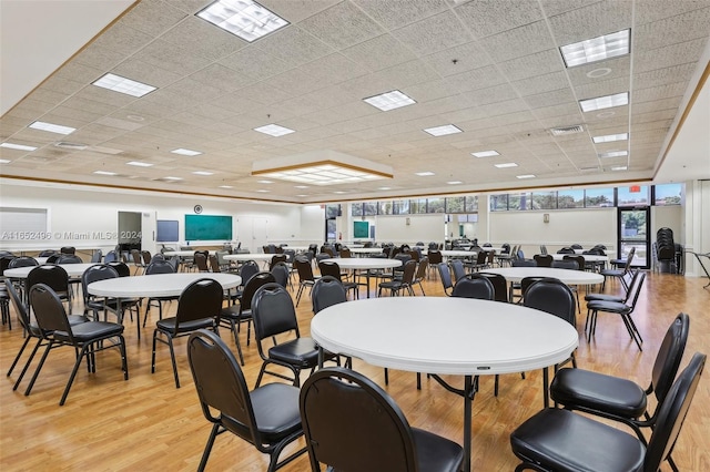 dining area featuring a drop ceiling, floor to ceiling windows, and light hardwood / wood-style floors