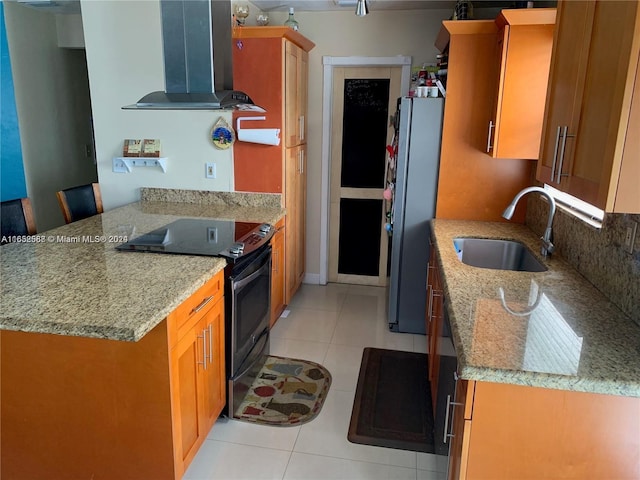 kitchen with island exhaust hood, sink, black / electric stove, light stone counters, and stainless steel refrigerator