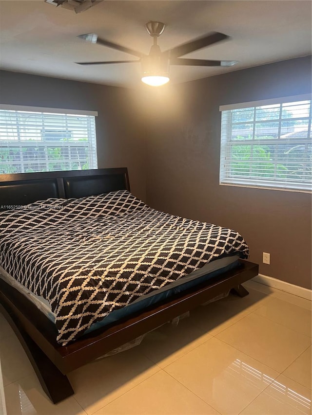 tiled bedroom featuring ceiling fan