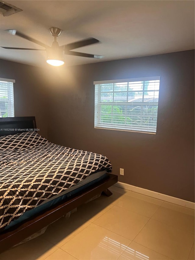 unfurnished bedroom with multiple windows, tile patterned flooring, and ceiling fan