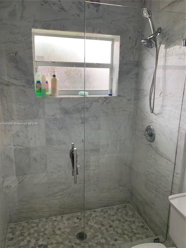 bathroom with tiled shower and toilet