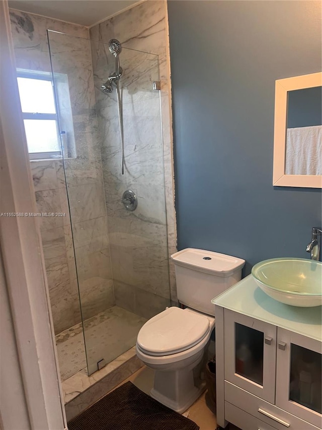 bathroom featuring vanity, toilet, and tiled shower