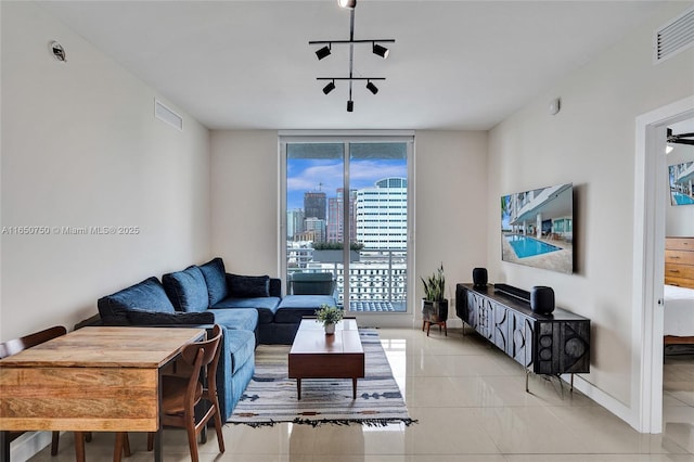 living area featuring track lighting, visible vents, baseboards, and light tile patterned flooring