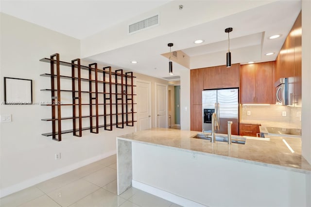 315 NE 3rd Ave Unit 1505, Fort Lauderdale, FL 33301 - kitchen with stainless steel appliances, a peninsula, brown cabinetry, light stone countertops, and recessed lighting