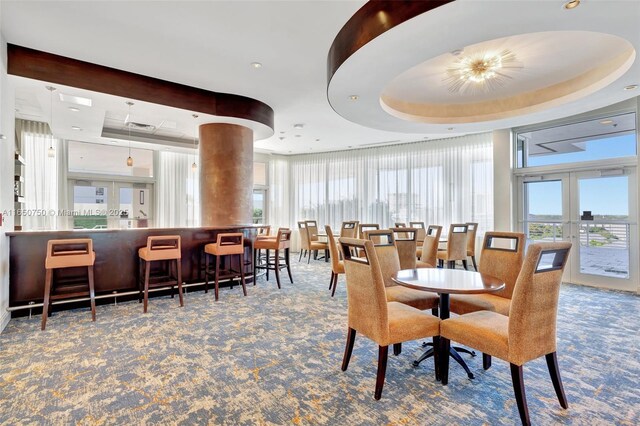 315 NE 3rd Ave Unit 1505, Fort Lauderdale, FL 33301 - dining space with carpet, a tray ceiling, french doors, and a community bar