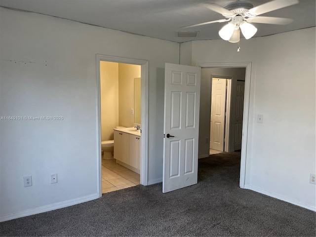 unfurnished bedroom featuring sink, light carpet, and ensuite bath