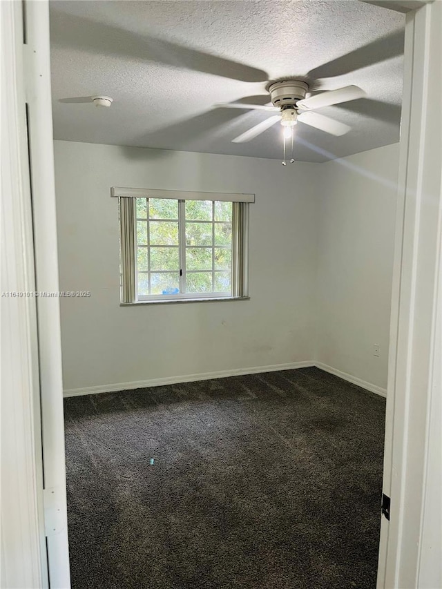 spare room featuring ceiling fan, a textured ceiling, and carpet