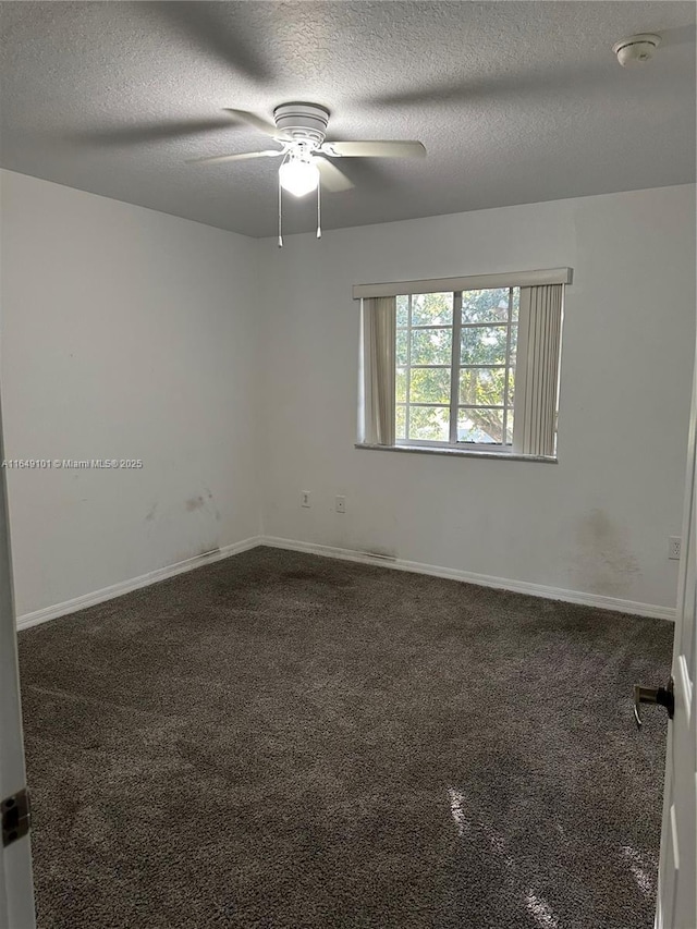 carpeted empty room with ceiling fan and a textured ceiling