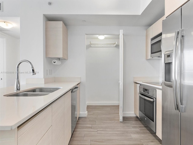 kitchen with light hardwood / wood-style floors, stainless steel appliances, and sink