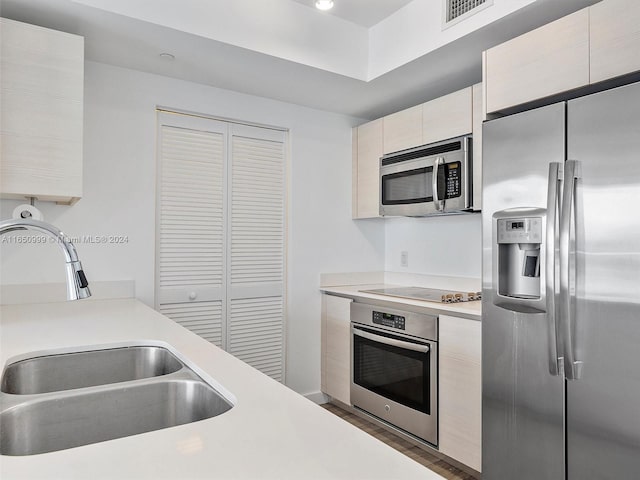 kitchen with appliances with stainless steel finishes, sink, and dark wood-type flooring